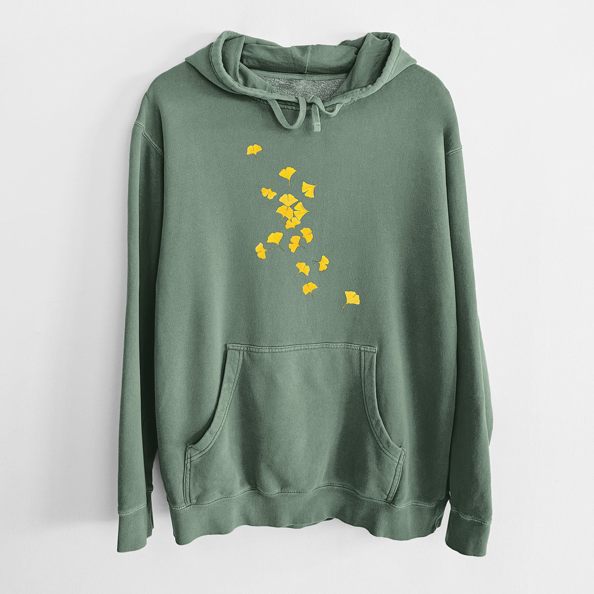 Alpine green pigment dyed hoodie laid flat, printed with a scatter of bright yellow fan-shaped ginkgo leaves falling.