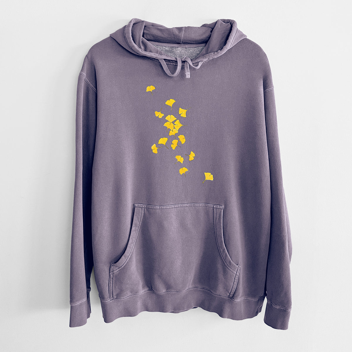 Plum purple pigment dyed hoodie laid flat, printed with a scatter of bright yellow fan-shaped ginkgo leaves falling.