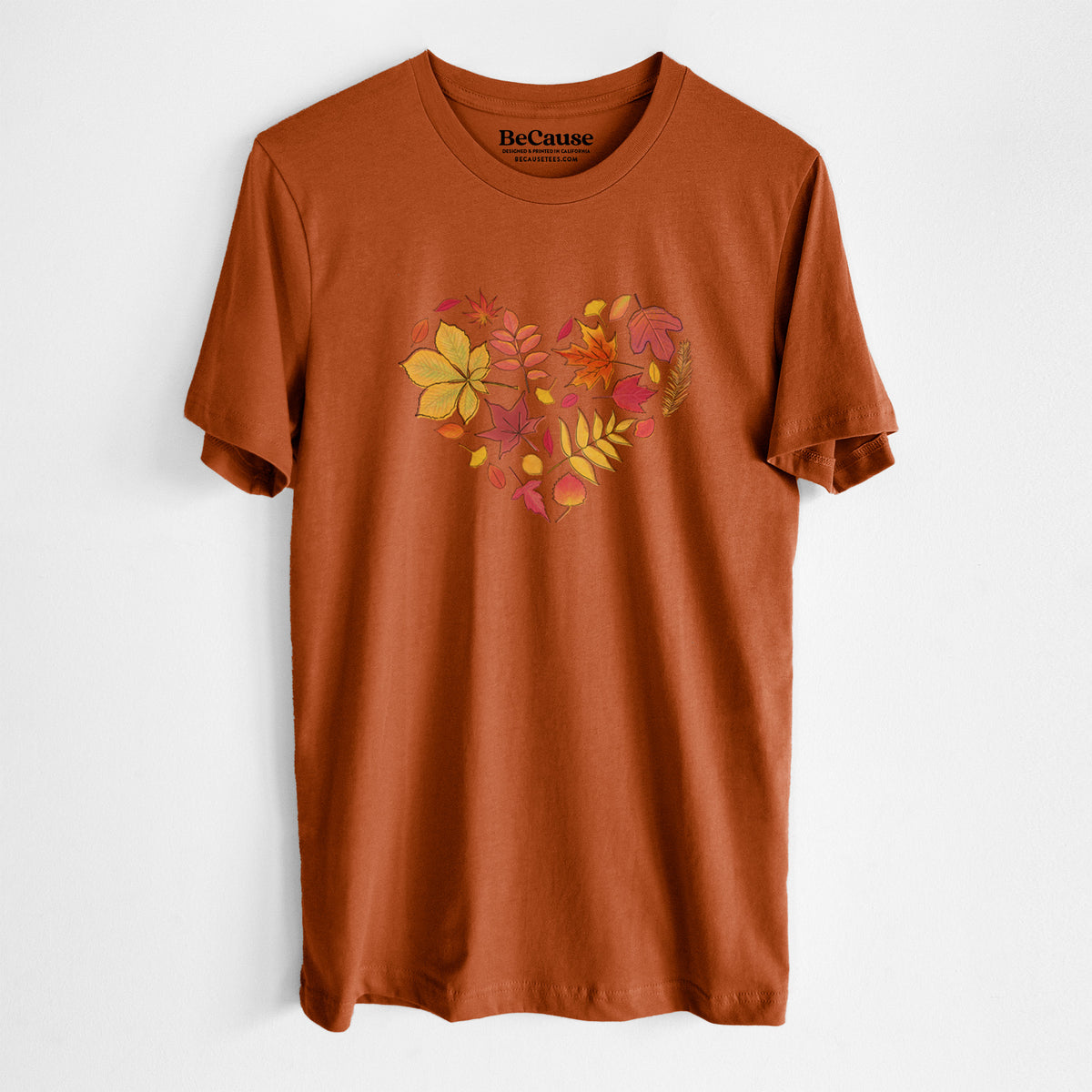 Autumn lightweight cotton t-shirt laid flat, printed with a full-color heart shape made of autumn leaves in orange, red and yellow.