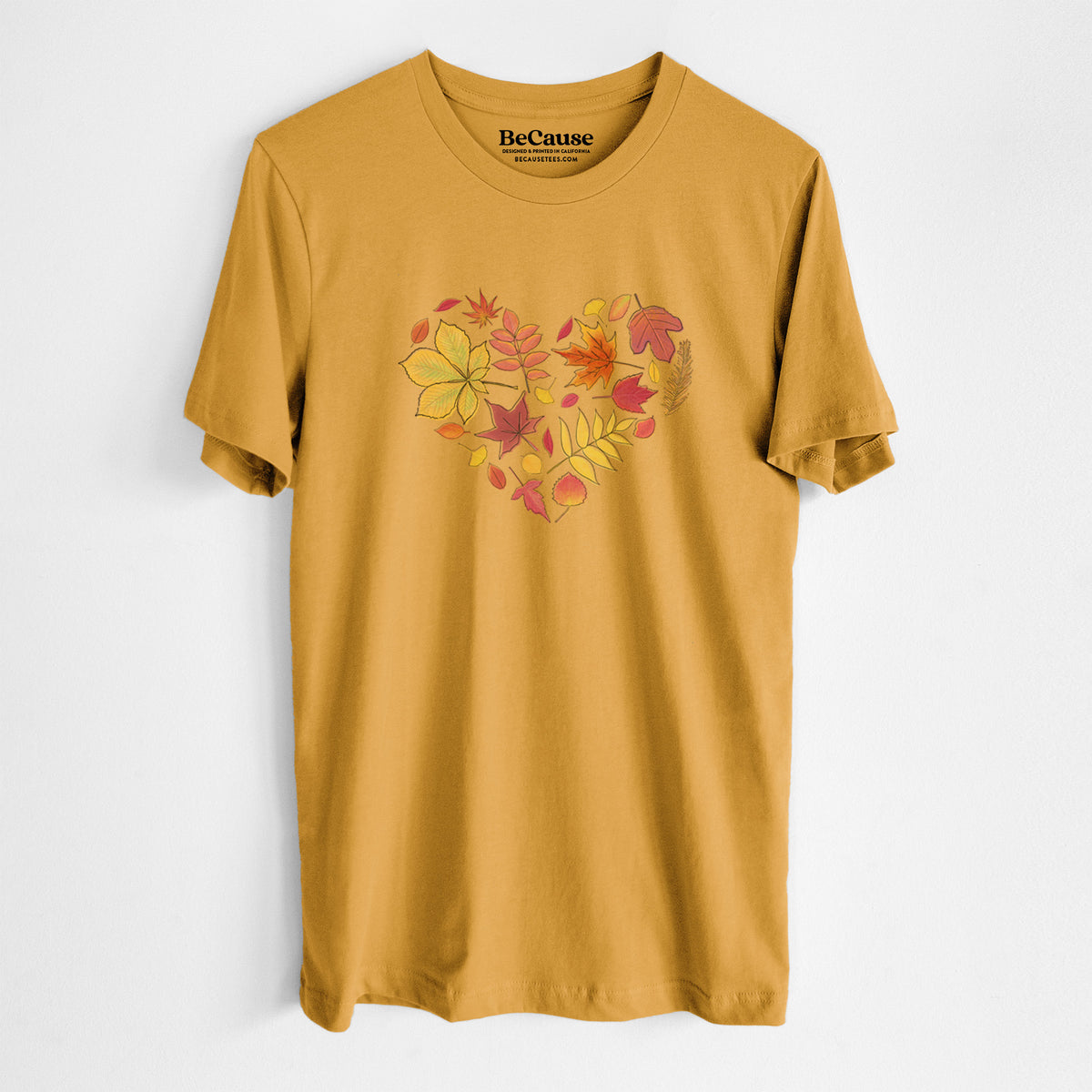 Mustard yellow lightweight cotton t-shirt laid flat, printed with a full-color heart shape made of autumn leaves in orange, red and yellow.