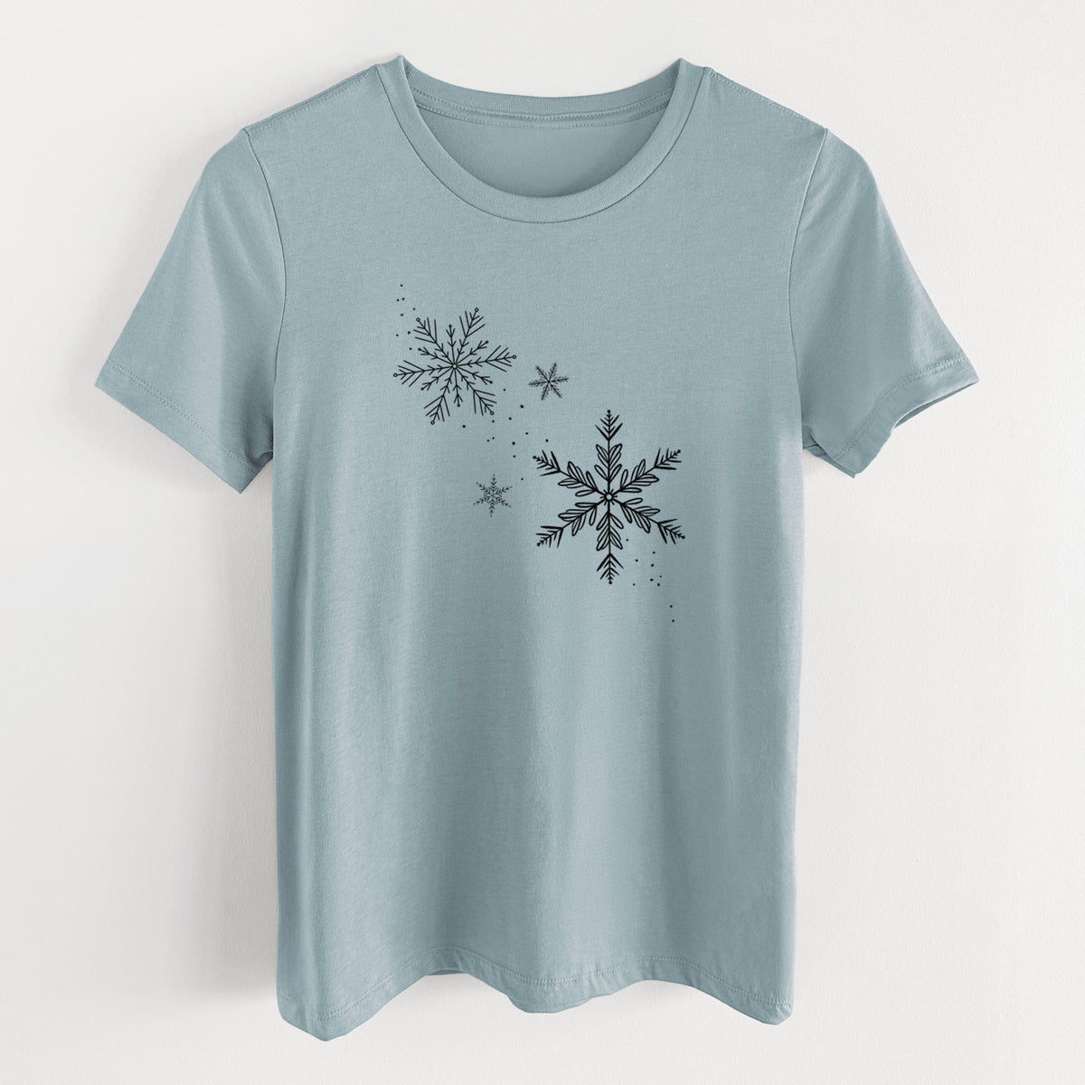 Vintage denim women's relaxed fit cotton t-shirt laid flat, printed with delicate snowflakes of different sizes falling.