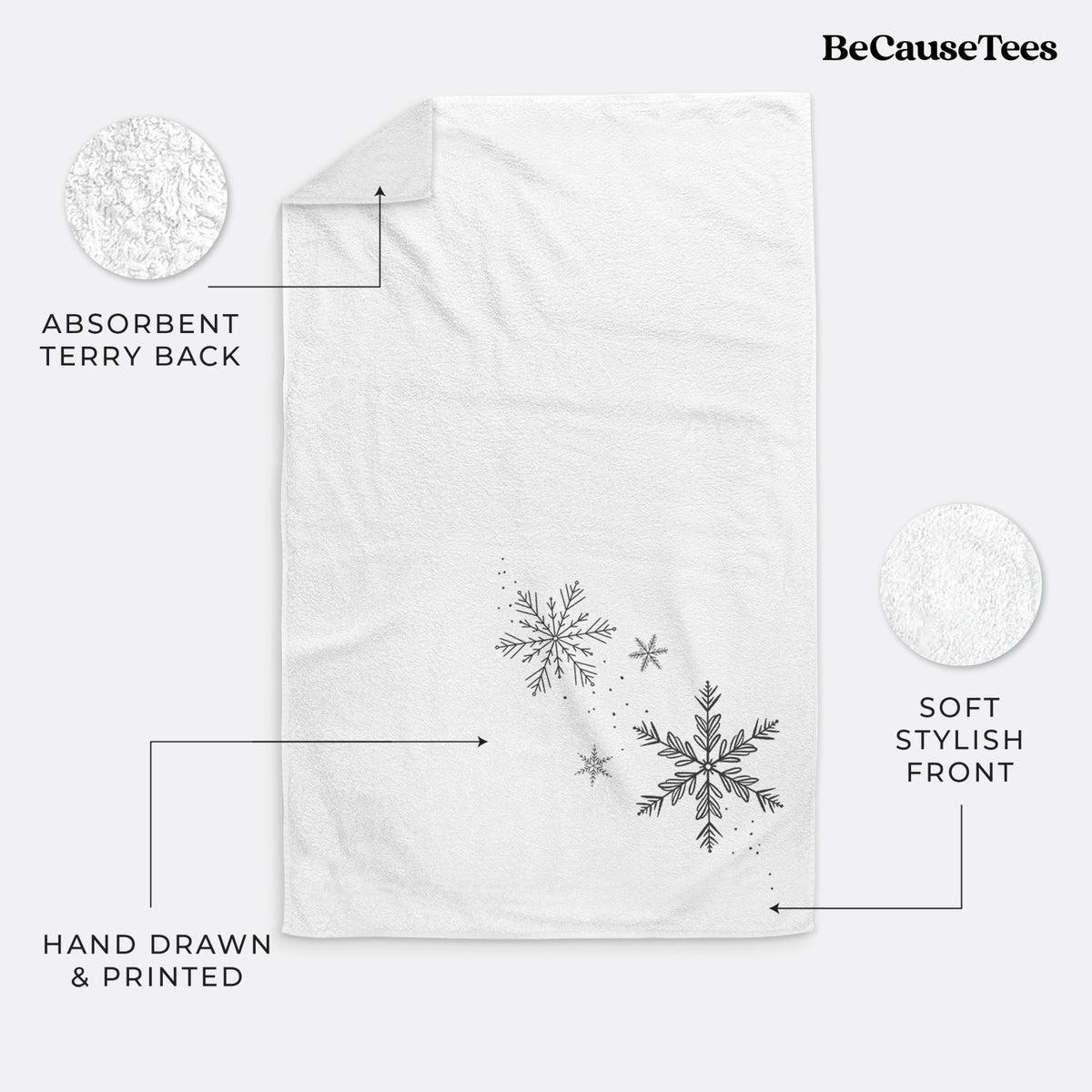 White hand towel printed with delicate snowflakes of different sizes falling.