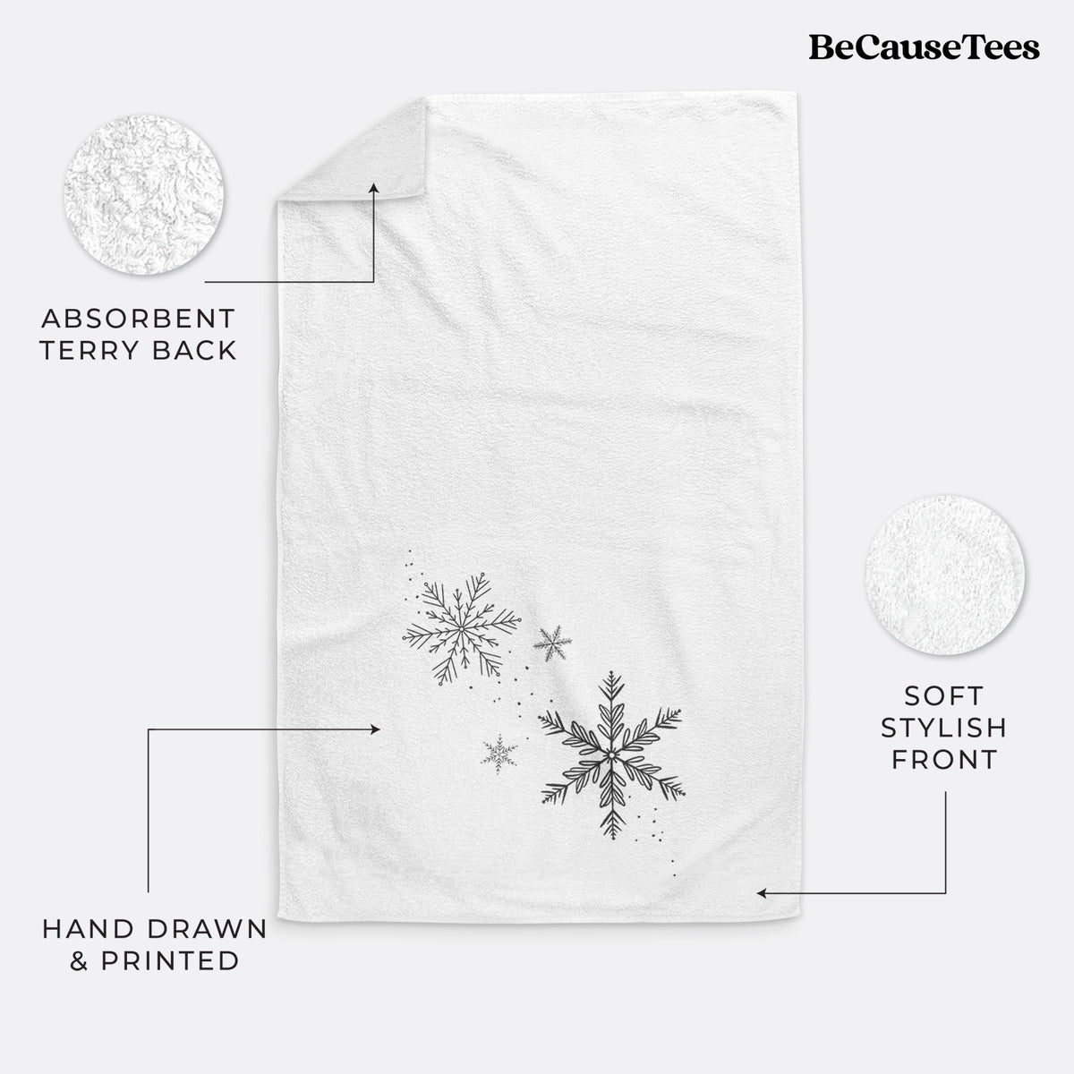 White hand towel printed with delicate snowflakes of different sizes falling.