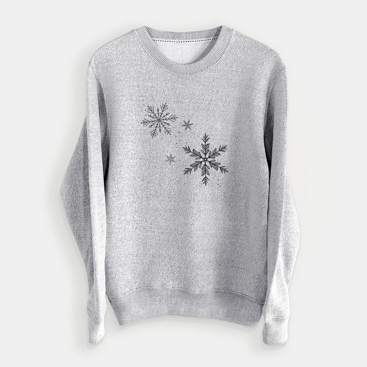 Salt and pepper knit sweatshirt laid flat, printed with delicate snowflakes of different sizes falling.