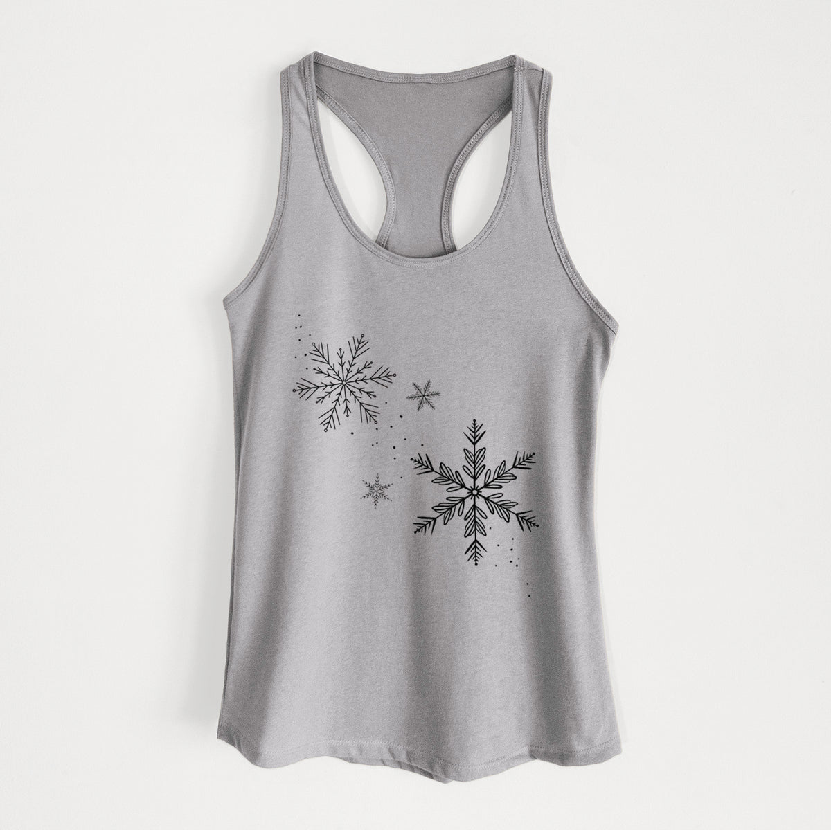 Heather grey women's racerback tank top laid flat, printed with delicate snowflakes of different sizes falling.
