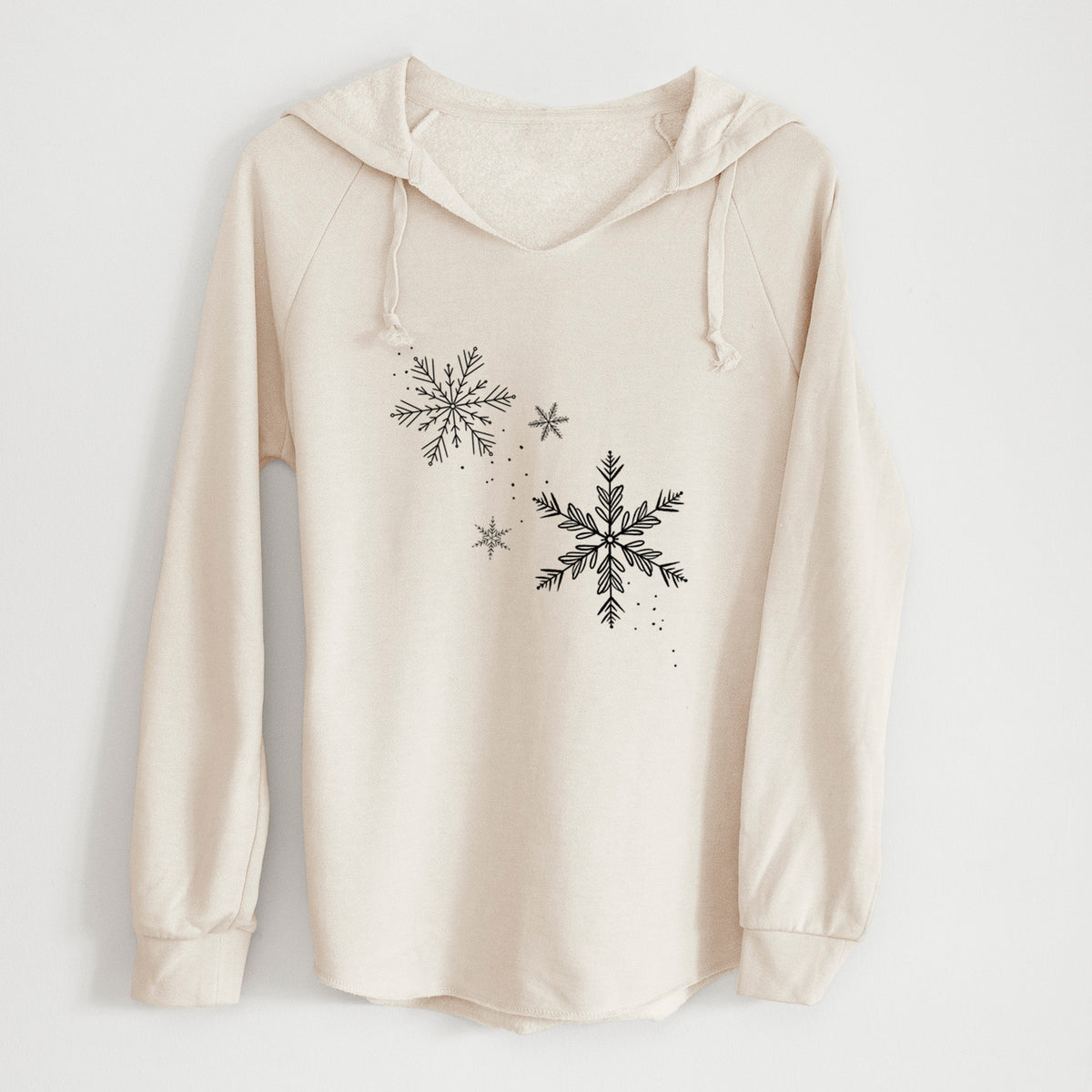 Bone cream women's Cali Wave hooded sweatshirt laid flat, printed with delicate snowflakes of different sizes falling.