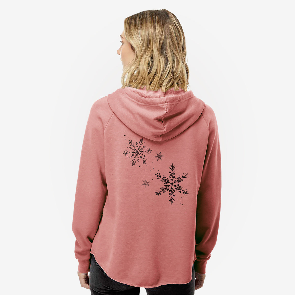 Woman wearing a dusty rose women's Cali Wave zip-up sweatshirt printed with delicate snowflakes of different sizes falling, seen from behind.