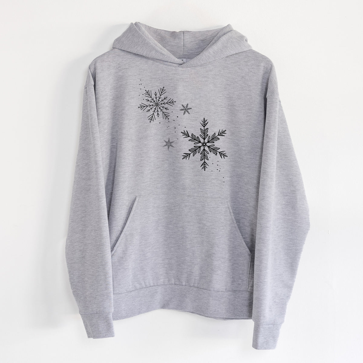 Falling Snowflakes - Statement Midweight Hoodie in Heather Grey, hanging on a white wall, with a front kangaroo pocket and no drawcords.