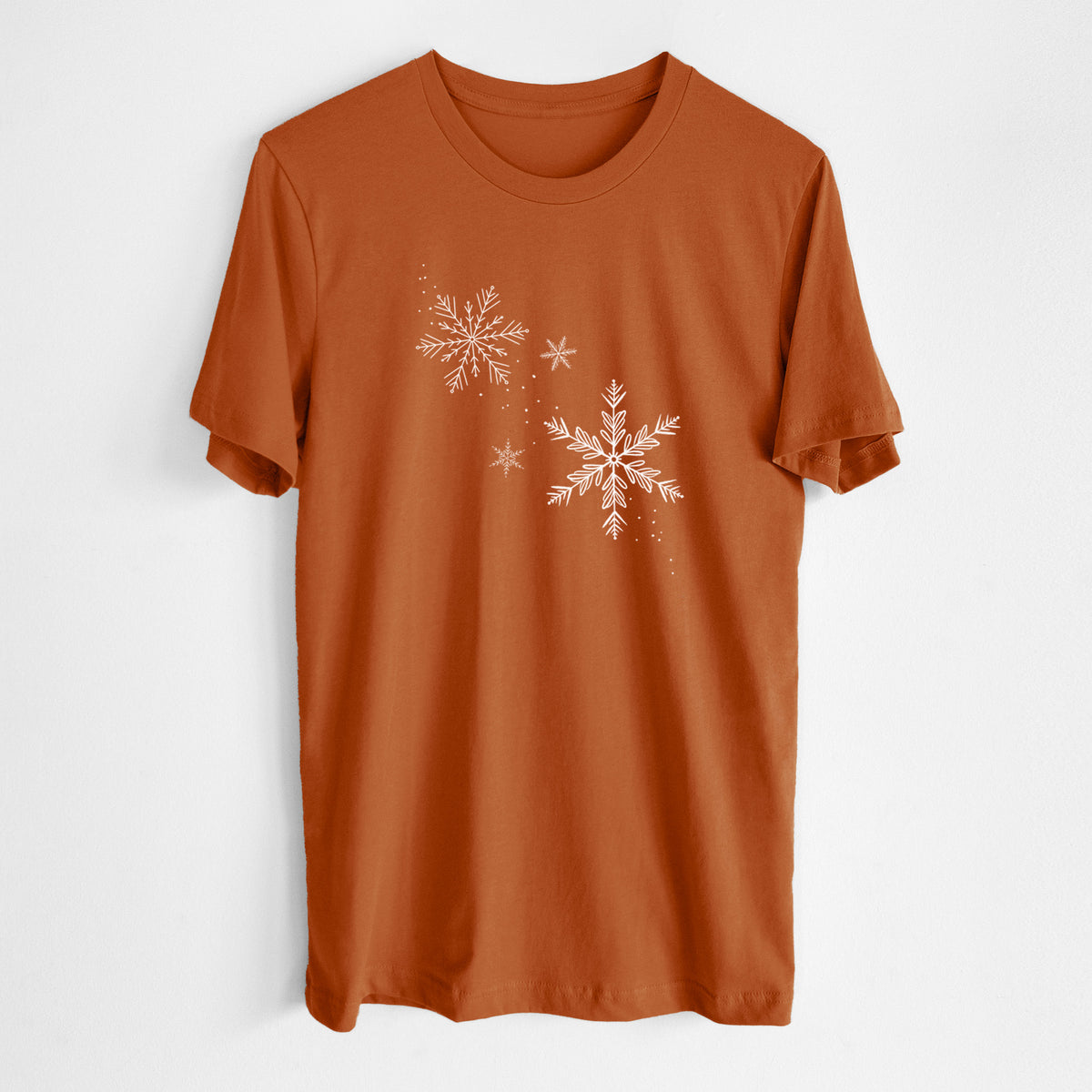 Autumn lightweight cotton t-shirt laid flat, printed with delicate white snowflakes of different sizes falling.