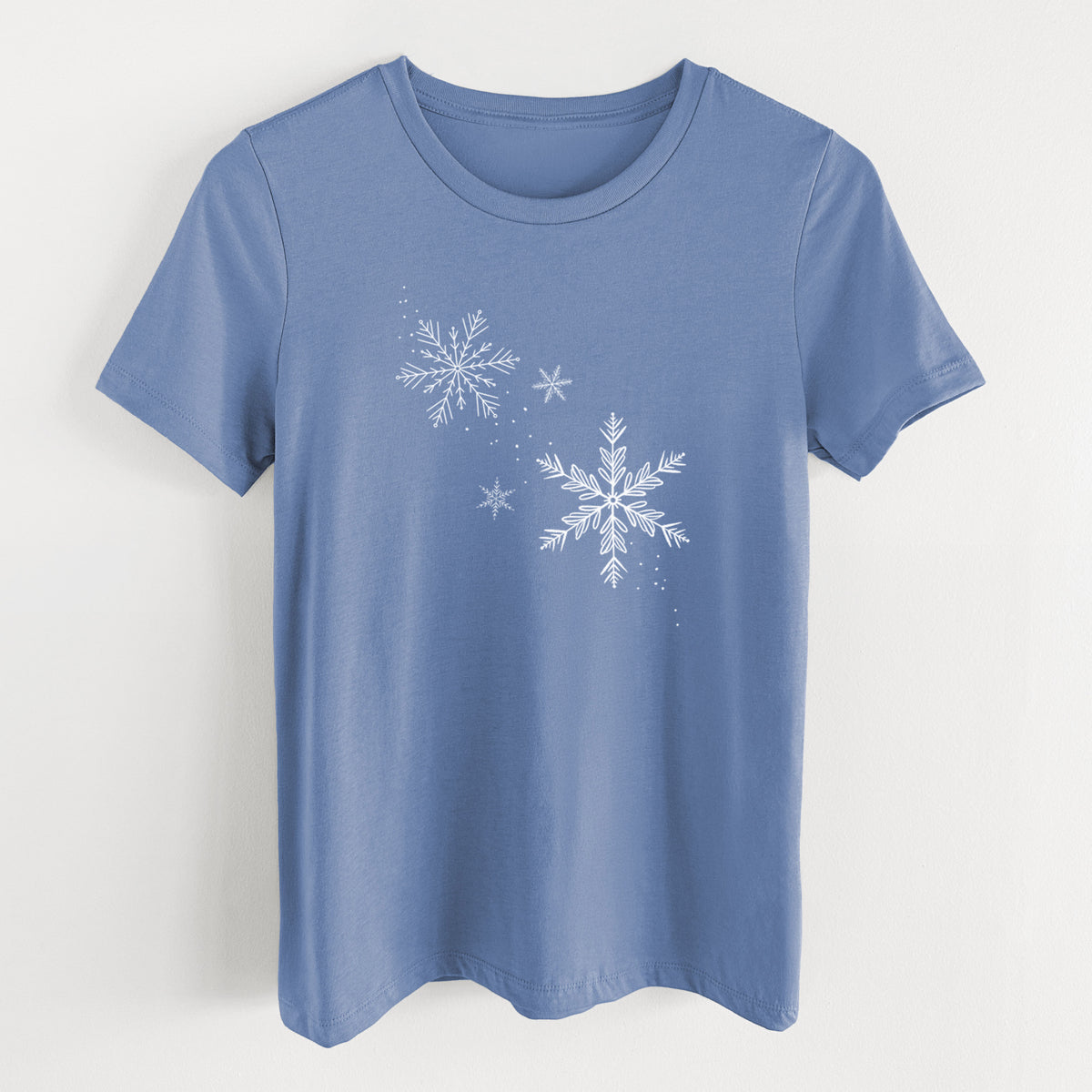 Blue bell women's relaxed fit cotton t-shirt laid flat, printed with delicate white snowflakes of different sizes falling.