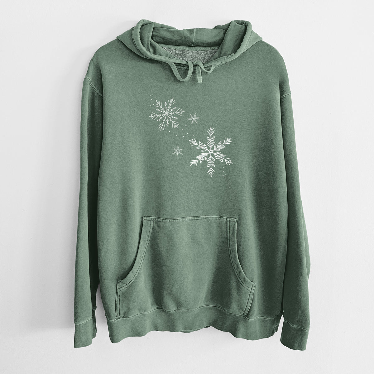 Alpine green pigment dyed hoodie laid flat, printed with delicate white snowflakes of different sizes falling.