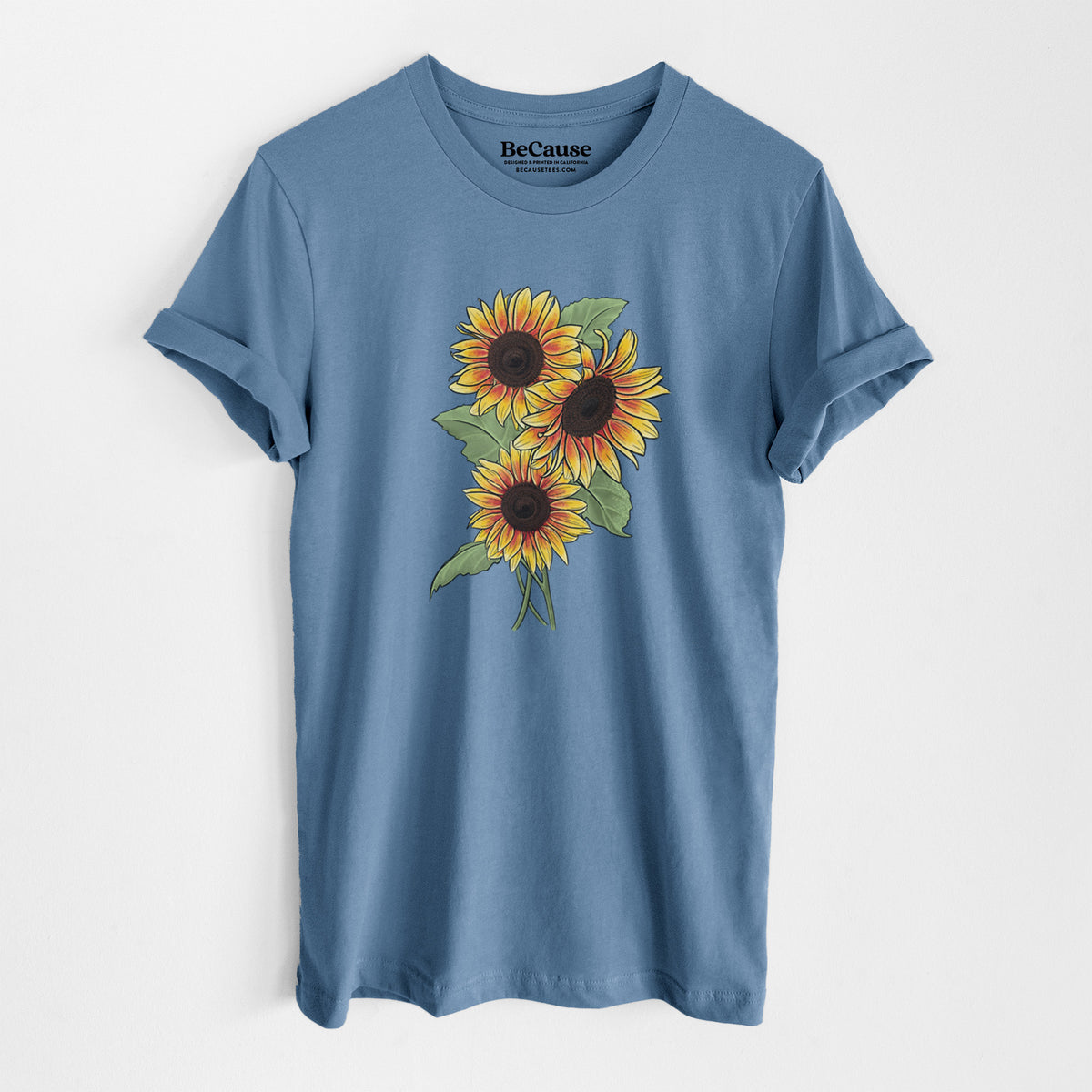 Steel blue lightweight cotton t-shirt laid flat, printed with a full-color illustration of a bunch of yellow and orange sunflowers.