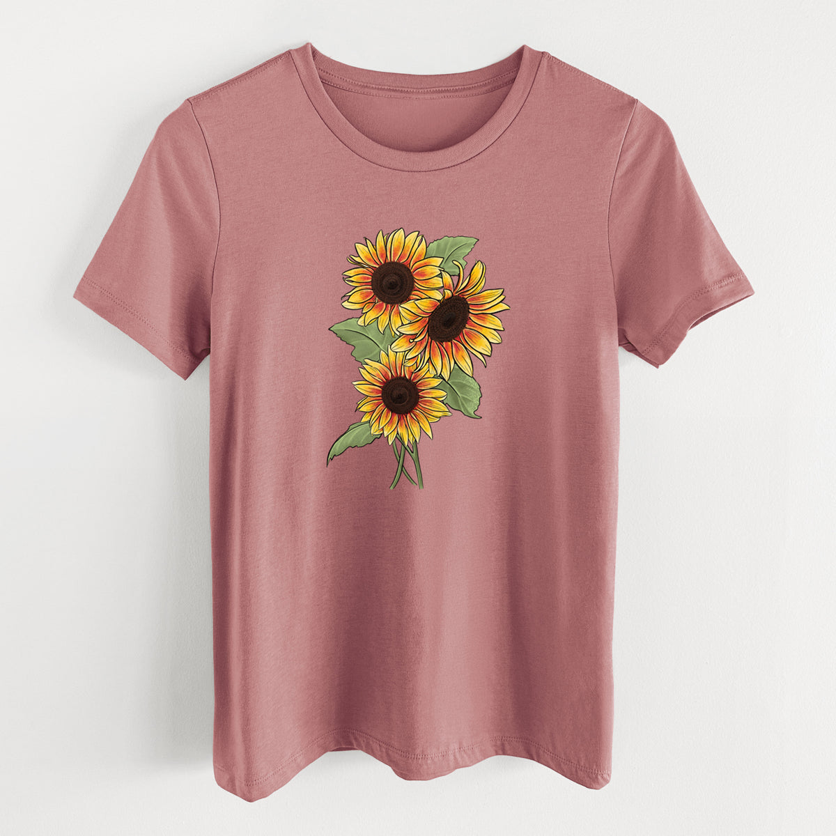 Mauve pink women's relaxed fit cotton t-shirt laid flat, printed with a full-color illustration of a bunch of yellow and orange sunflowers.