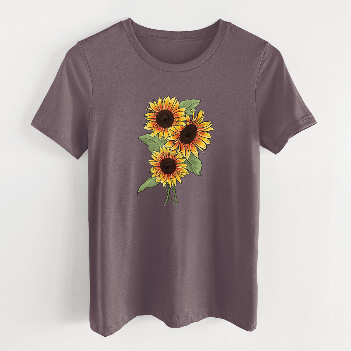 Purple storm women's relaxed fit cotton t-shirt laid flat, printed with a full-color illustration of a bunch of yellow and orange sunflowers.