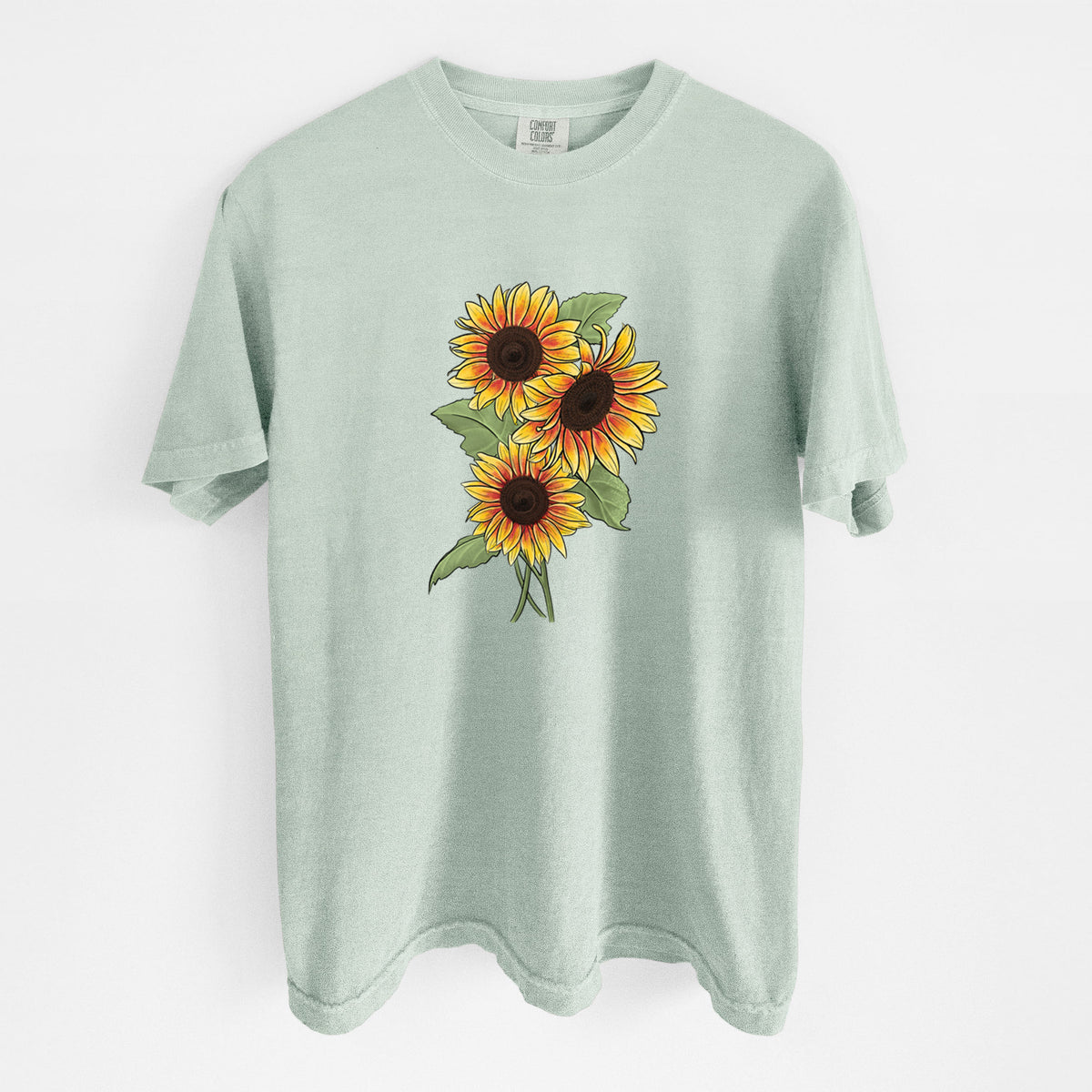Bay green Comfort Colors t-shirt laid flat, printed with a full-color illustration of a bunch of yellow and orange sunflowers.