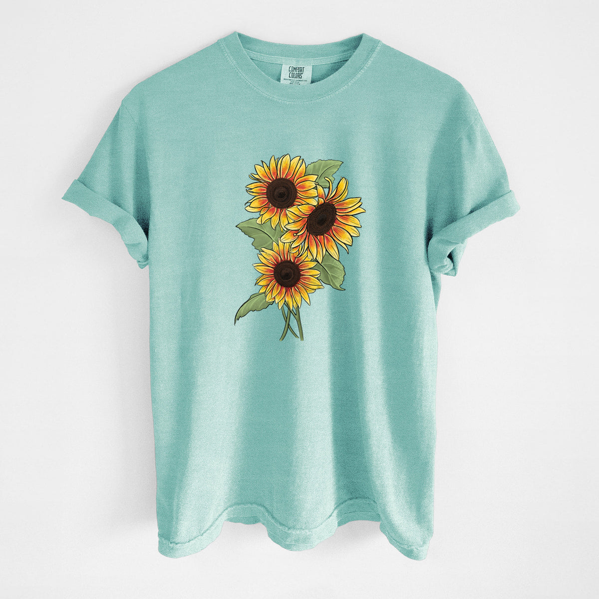 Chalky mint Comfort Colors t-shirt laid flat, printed with a full-color illustration of a bunch of yellow and orange sunflowers.