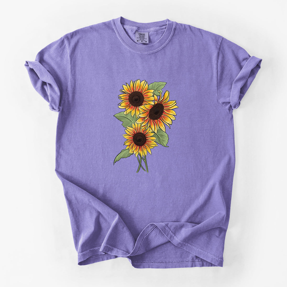 Violet purple Comfort Colors t-shirt laid flat, printed with a full-color illustration of a bunch of yellow and orange sunflowers.