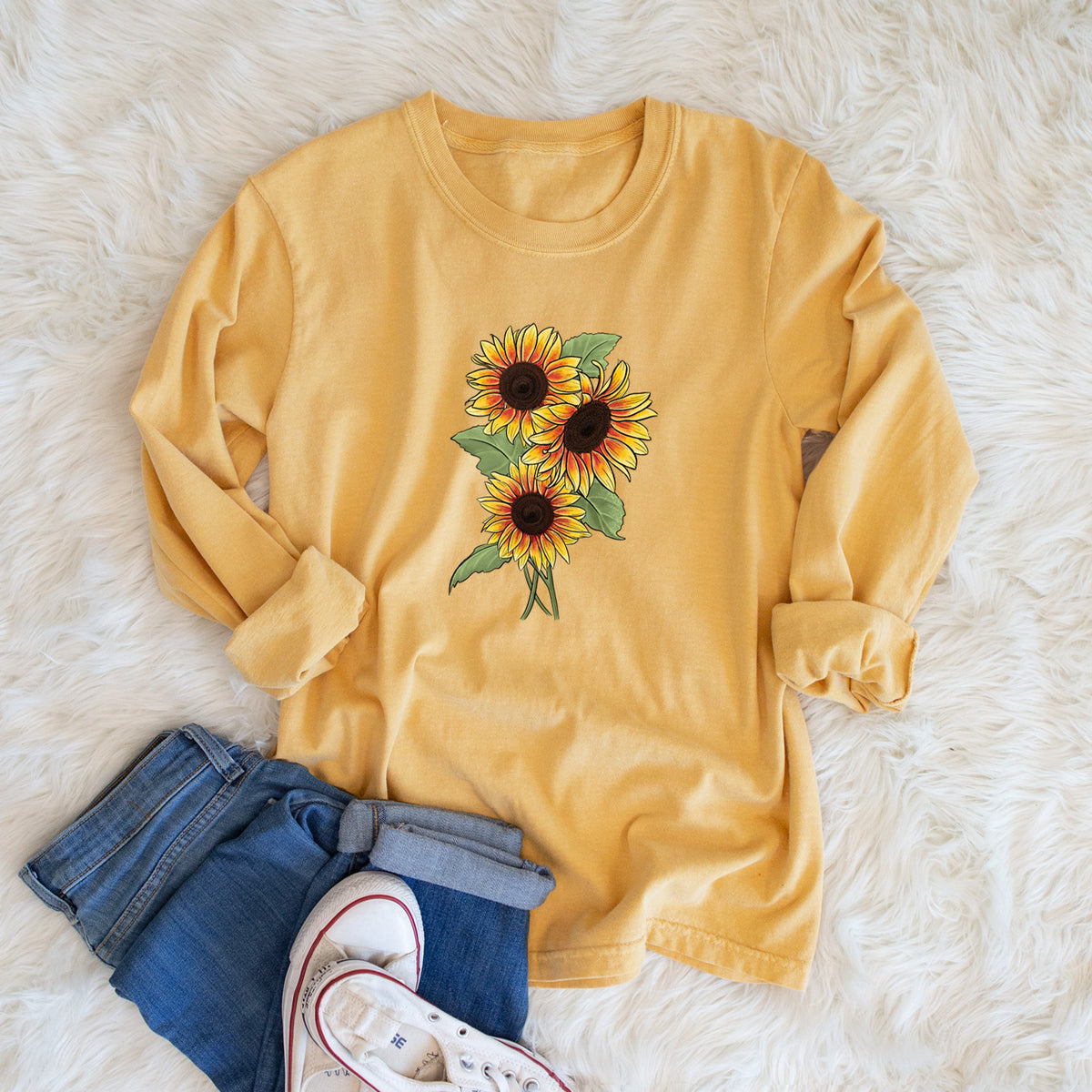 Golden wheat yellow Comfort Colors long sleeve shirt printed with a full-color illustration of a bunch of yellow and orange sunflowers, shown in a lifestyle photo.