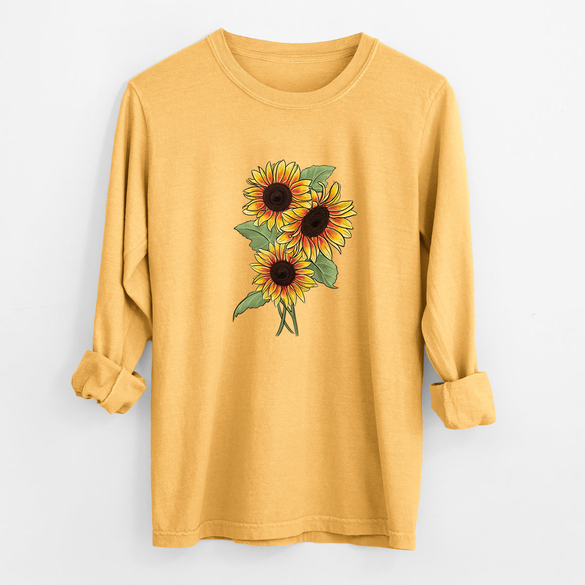 Golden wheat yellow Comfort Colors long sleeve shirt laid flat with the cuffs rolled, printed with a full-color illustration of a bunch of yellow and orange sunflowers.