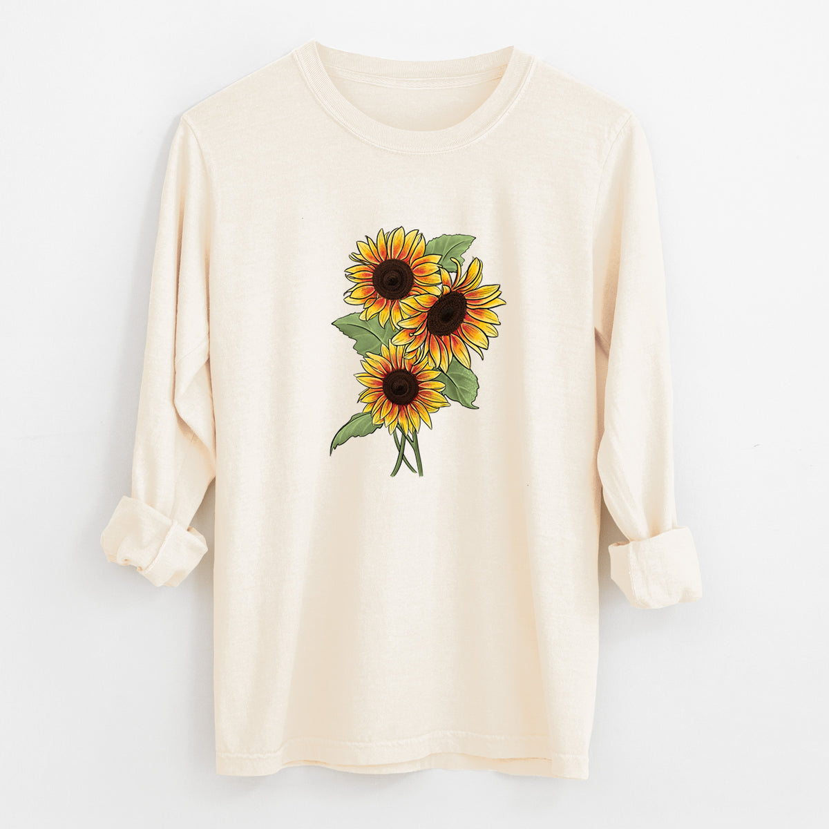 Ivory Comfort Colors long sleeve shirt laid flat with the cuffs rolled, printed with a full-color illustration of a bunch of yellow and orange sunflowers.