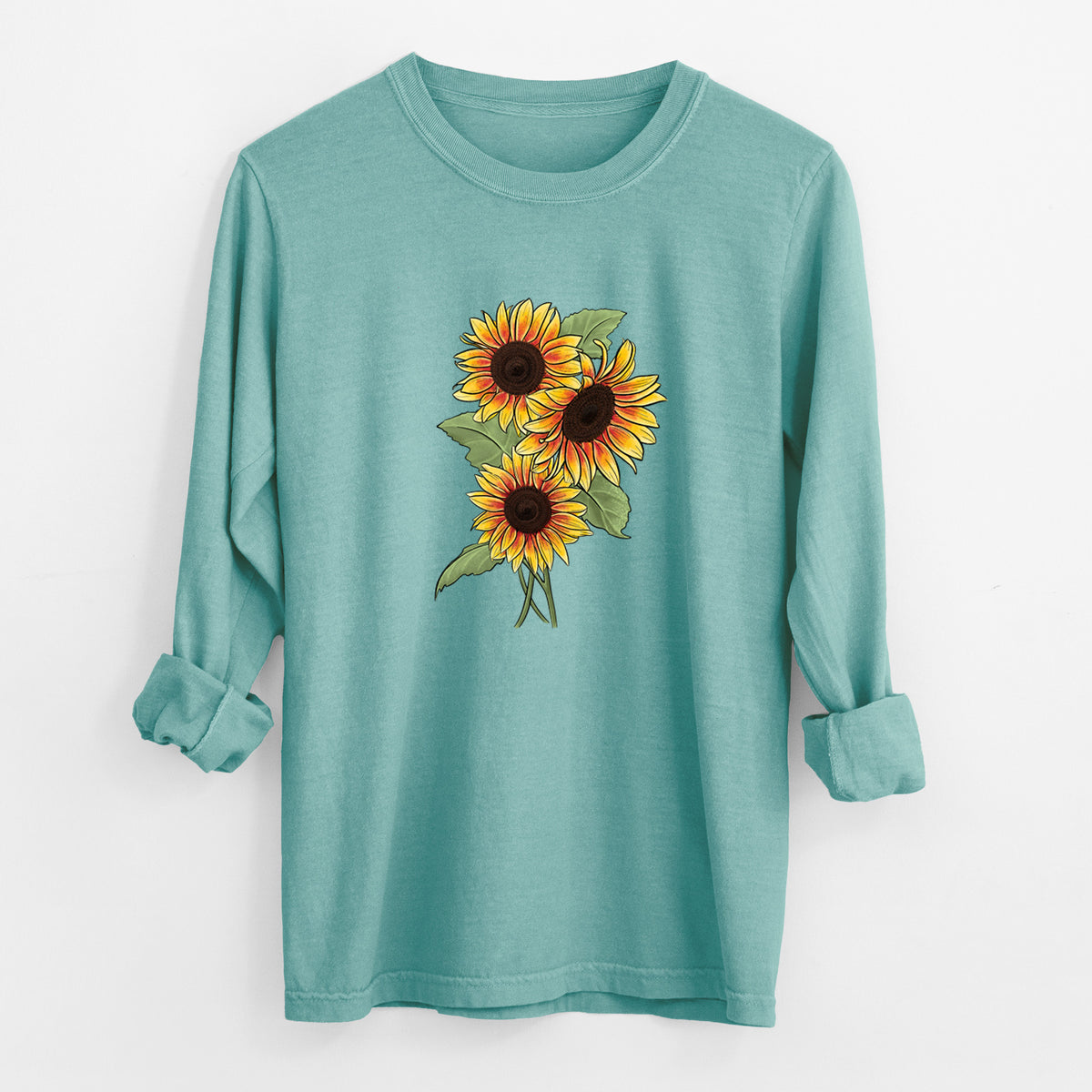Reef green Comfort Colors long sleeve shirt laid flat with the cuffs rolled, printed with a full-color illustration of a bunch of yellow and orange sunflowers.