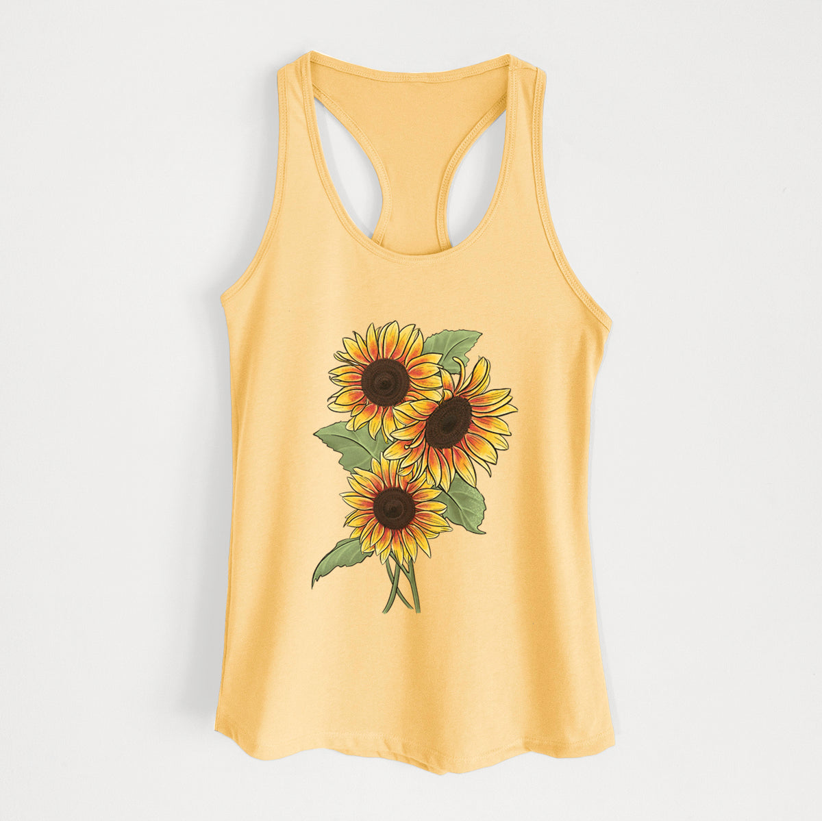 Banana cream women's racerback tank top laid flat, printed with a full-color illustration of a bunch of yellow and orange sunflowers.