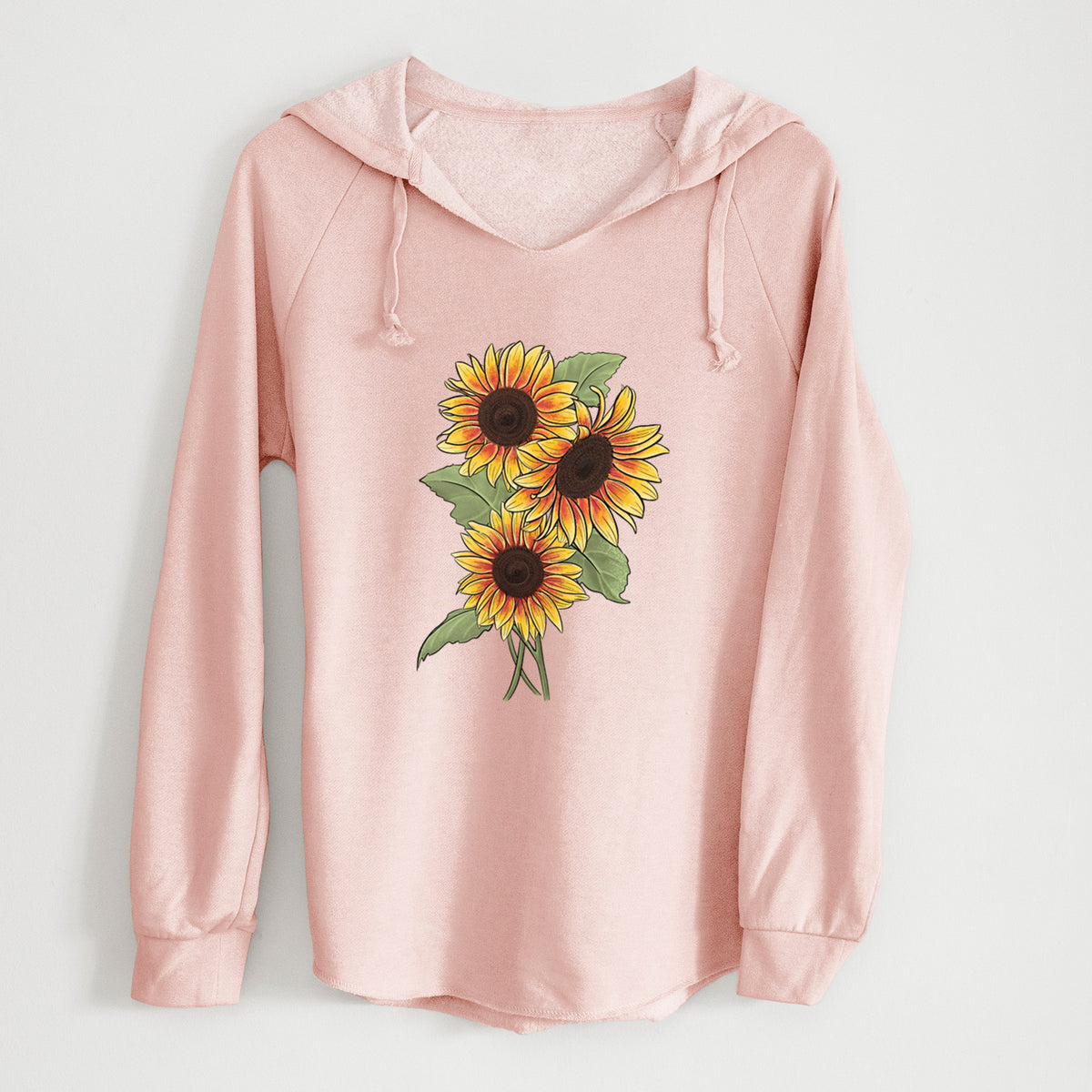 Blush pink women's Cali Wave hooded sweatshirt laid flat, printed with a full-color illustration of a bunch of yellow and orange sunflowers.