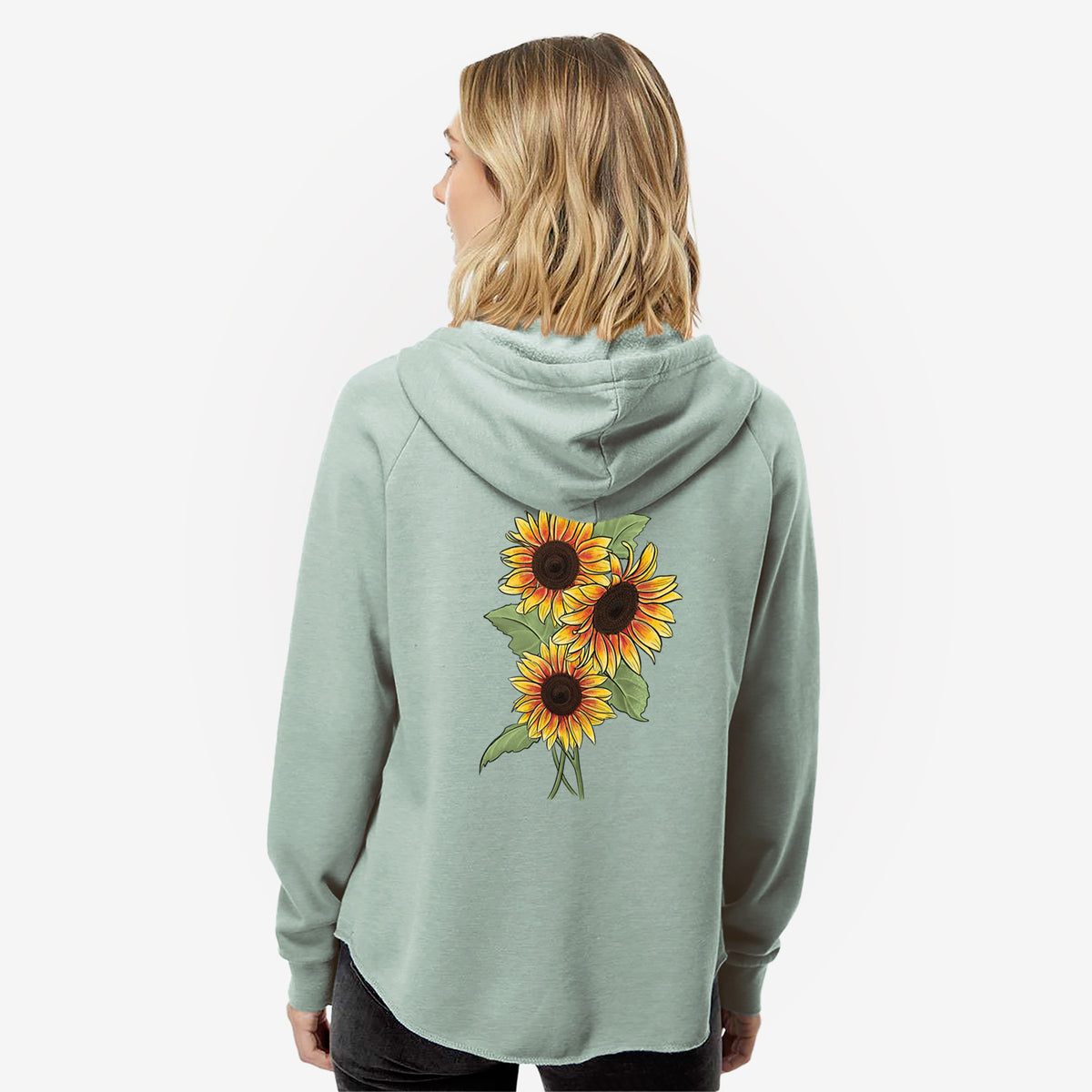 Woman wearing a sage green women's Cali Wave zip-up sweatshirt printed with a full-color illustration of a bunch of yellow and orange sunflowers, seen from behind.