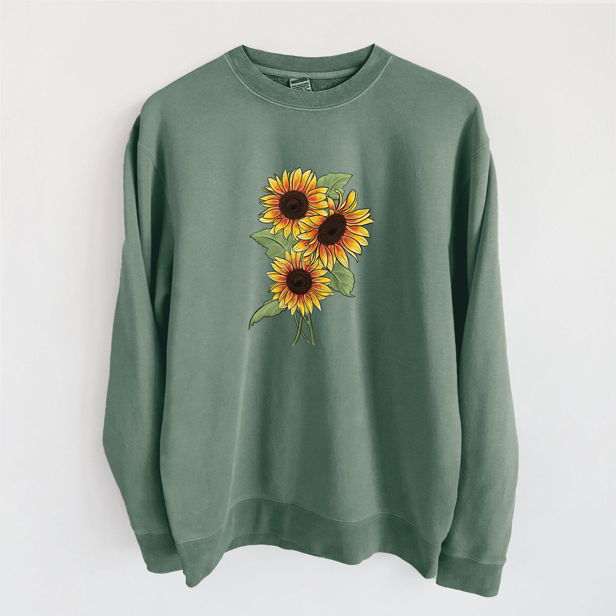 Alpine green pigment dyed crewneck sweatshirt laid flat, printed with a full-color illustration of a bunch of yellow and orange sunflowers.
