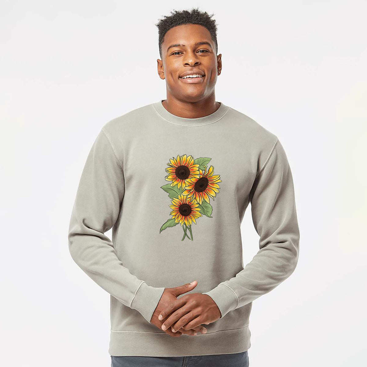 Model wearing a cement grey pigment dyed crewneck sweatshirt printed with a full-color illustration of a bunch of yellow and orange sunflowers.