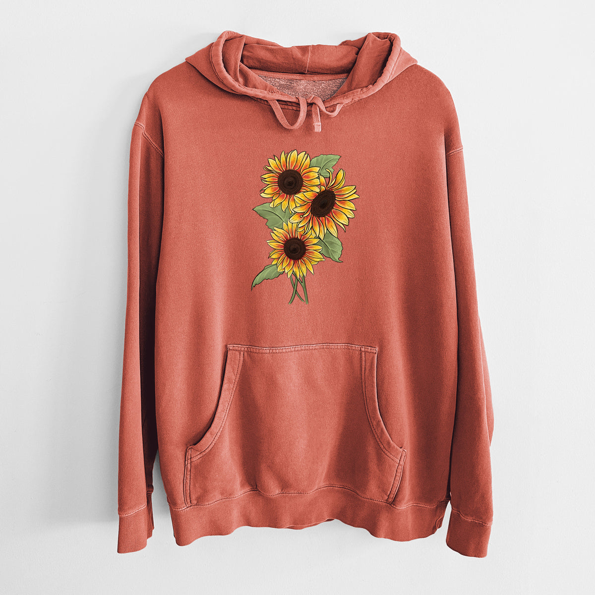 Amber orange pigment dyed hoodie laid flat, printed with a full-color illustration of a bunch of yellow and orange sunflowers.
