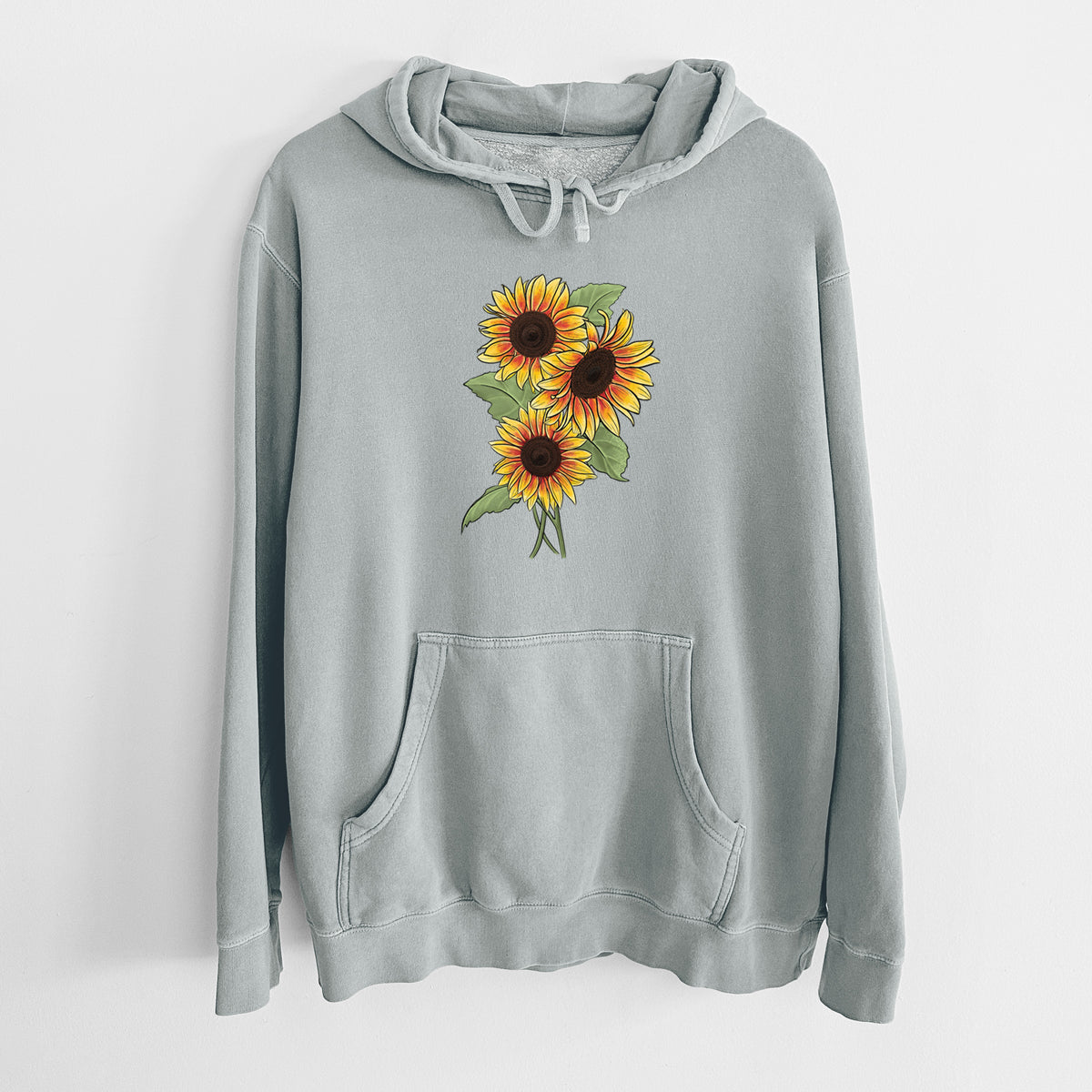 Sage green pigment dyed hoodie laid flat, printed with a full-color illustration of a bunch of yellow and orange sunflowers.