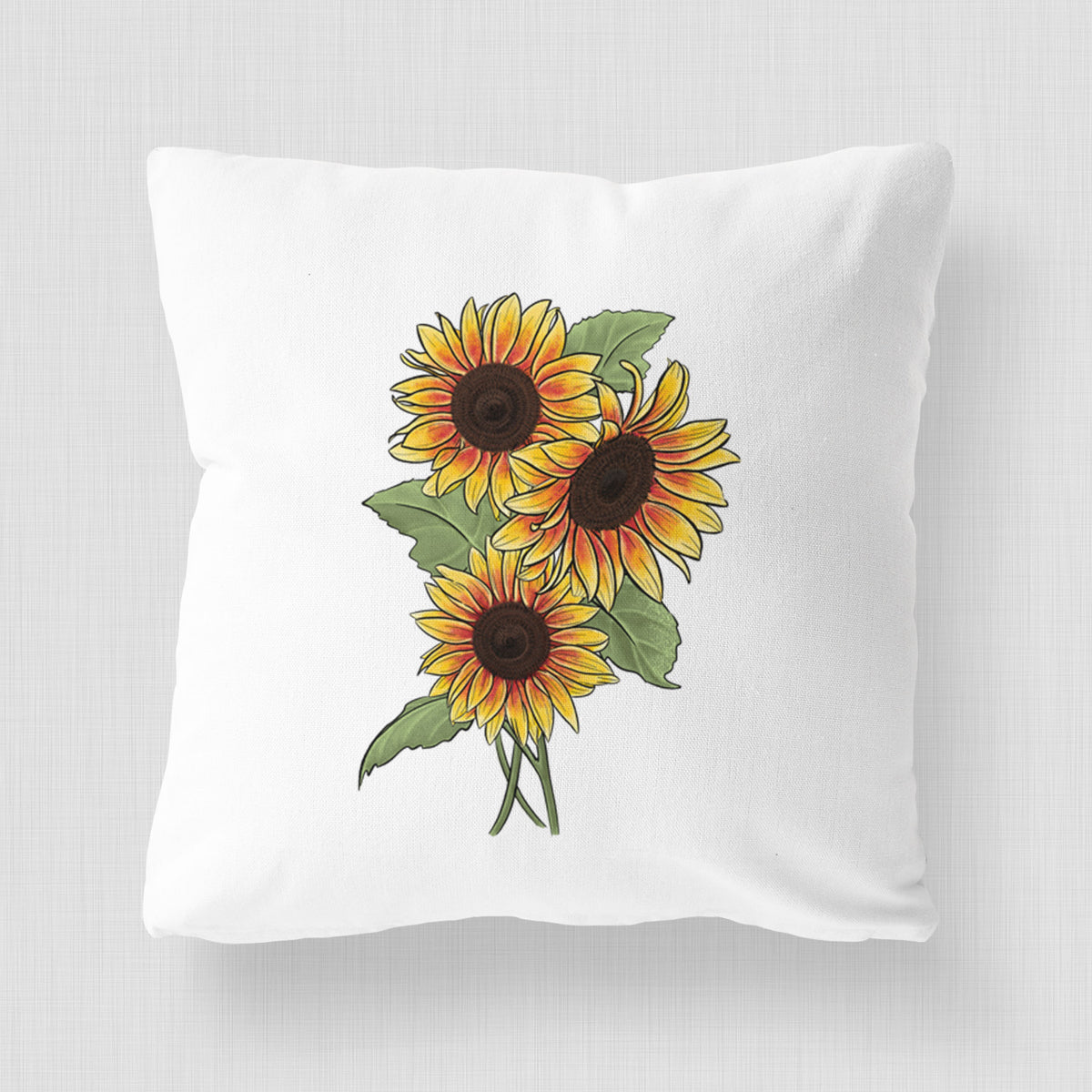 White pillow cover printed with a full-color illustration of a bunch of yellow and orange sunflowers.