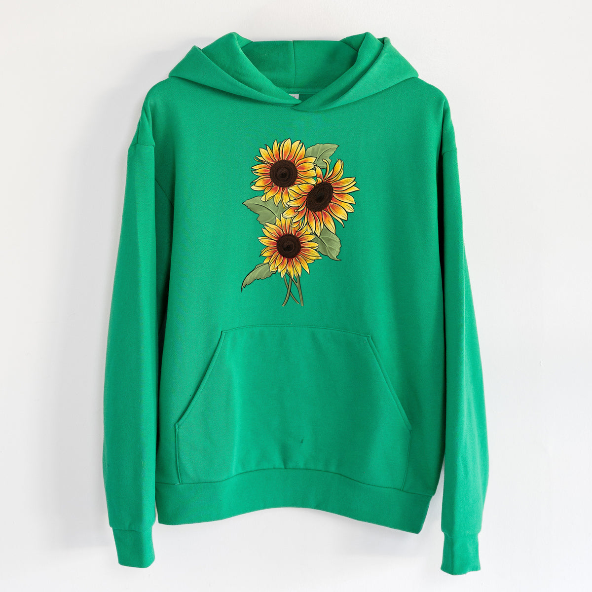 Firecracker Sunflowers - Helianthus annuus - Statement Midweight Hoodie in Kelly Green, hanging on a white wall, with a front kangaroo pocket and no drawcords.