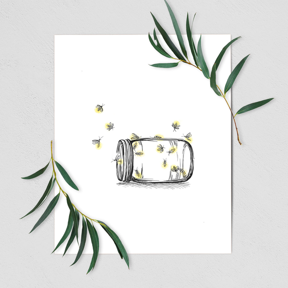 Art print of a mason jar with glowing yellow fireflies flying out of it, shown with eucalyptus leaves.