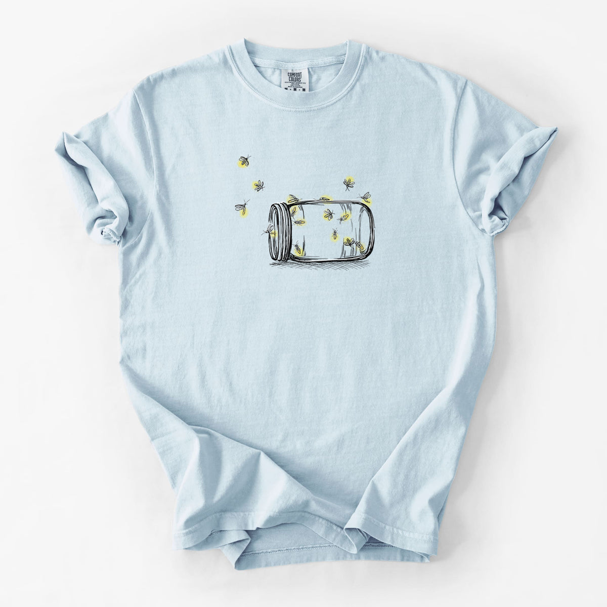 Chambray blue Comfort Colors t-shirt laid flat, printed with a mason jar with glowing yellow fireflies flying out of it.