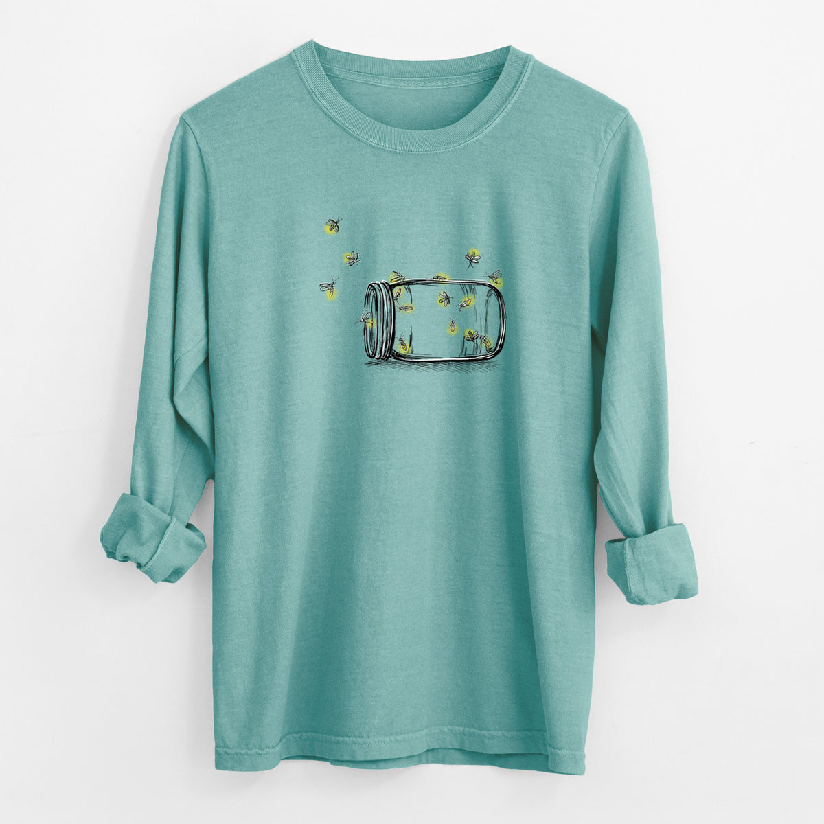 Reef green Comfort Colors long sleeve shirt laid flat with the cuffs rolled, printed with a mason jar with glowing yellow fireflies flying out of it.