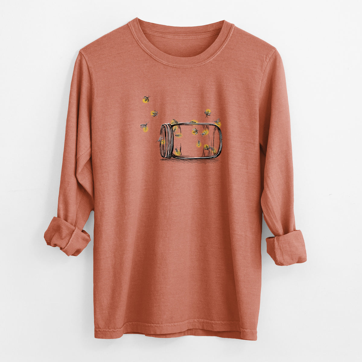 Yam burnt orange Comfort Colors long sleeve shirt laid flat with the cuffs rolled, printed with a mason jar with glowing yellow fireflies flying out of it.