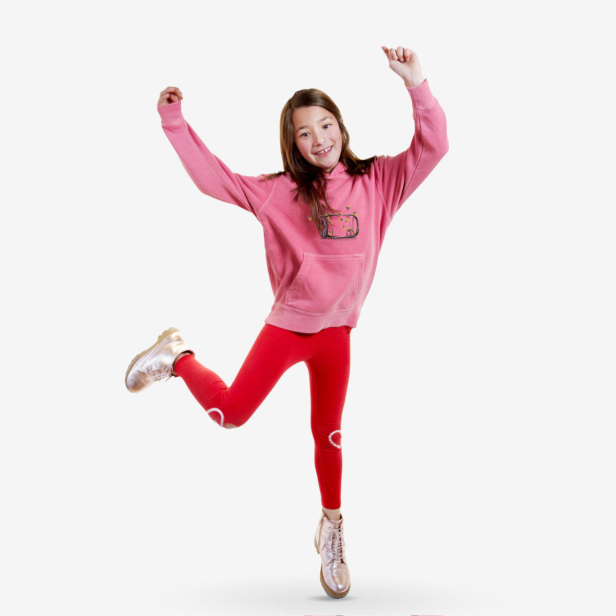 Girl wearing a youth pigment dyed hoodie printed with a mason jar with glowing yellow fireflies flying out of it.