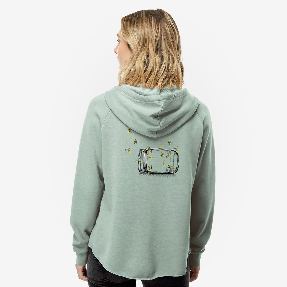 Woman wearing a sage green women's Cali Wave zip-up sweatshirt printed with a mason jar with glowing yellow fireflies flying out of it, seen from behind.