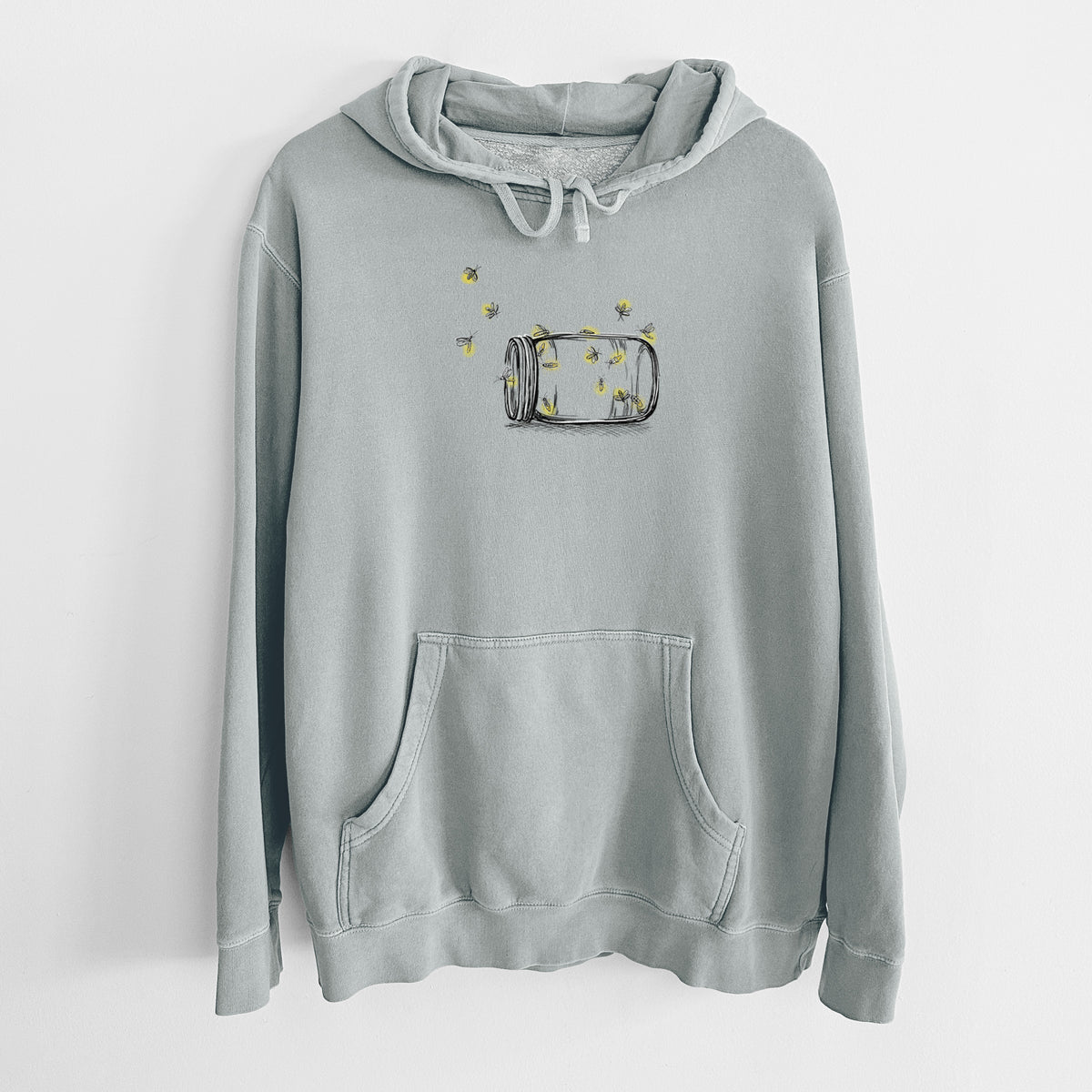 Sage green pigment dyed hoodie laid flat, printed with a mason jar with glowing yellow fireflies flying out of it.