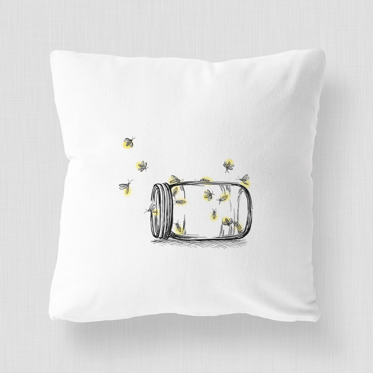 White pillow cover printed with a mason jar with glowing yellow fireflies flying out of it.