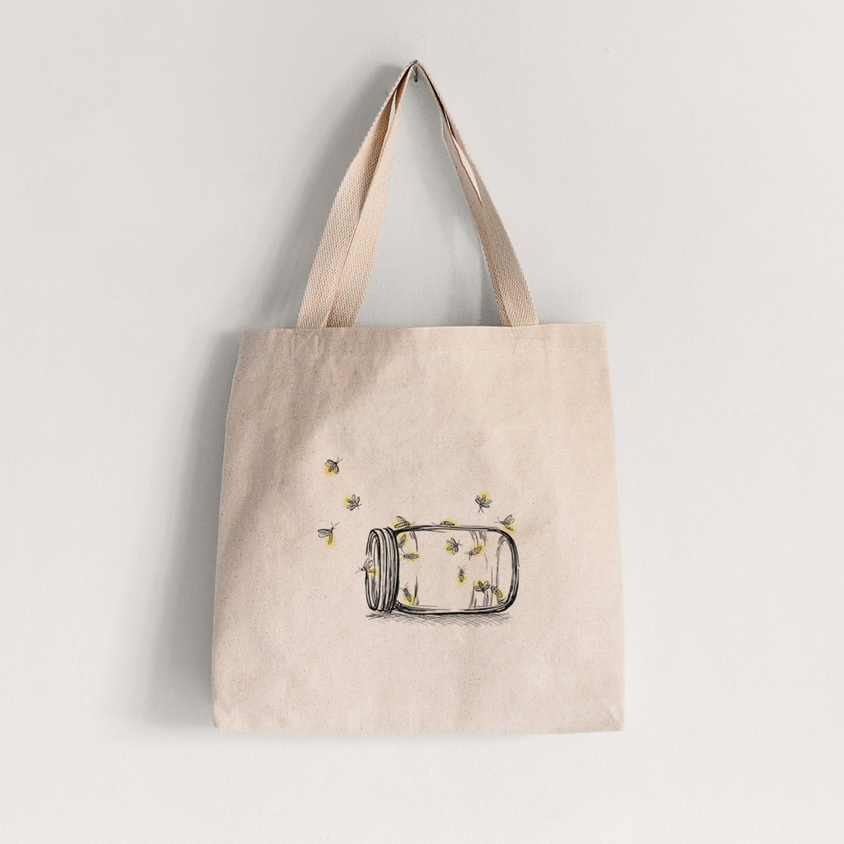 Natural canvas tote bag printed with a mason jar with glowing yellow fireflies flying out of it.