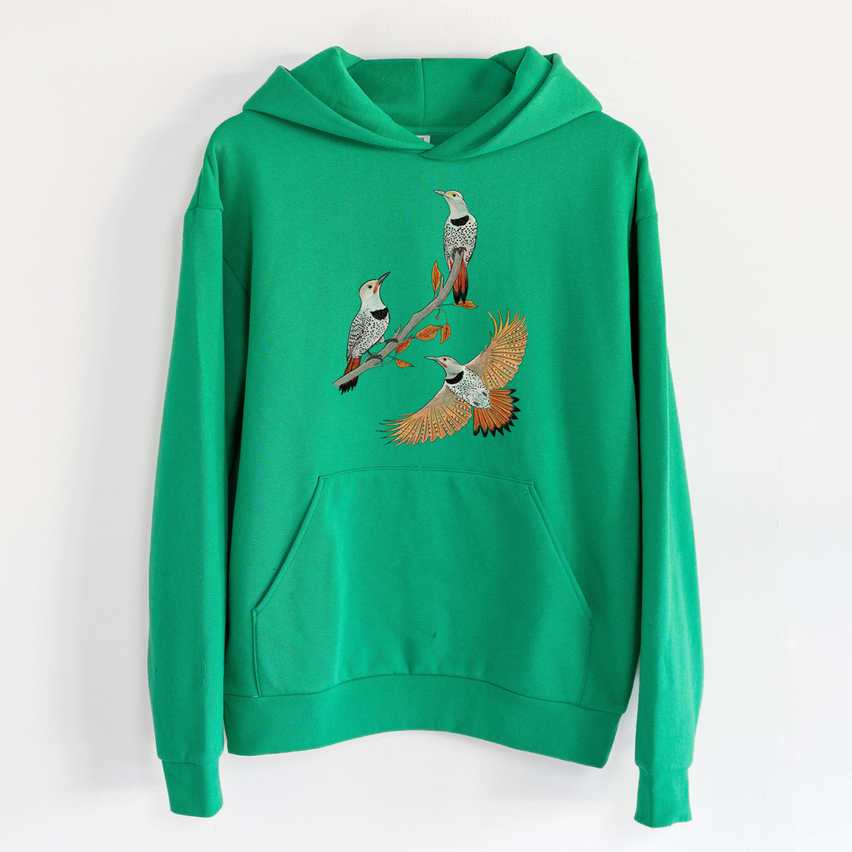 Northern Flickers (Red-shafted) - Colaptes auratus - Statement Midweight Hoodie in Kelly Green, hanging on a white wall, with a front kangaroo pocket and no drawcords.