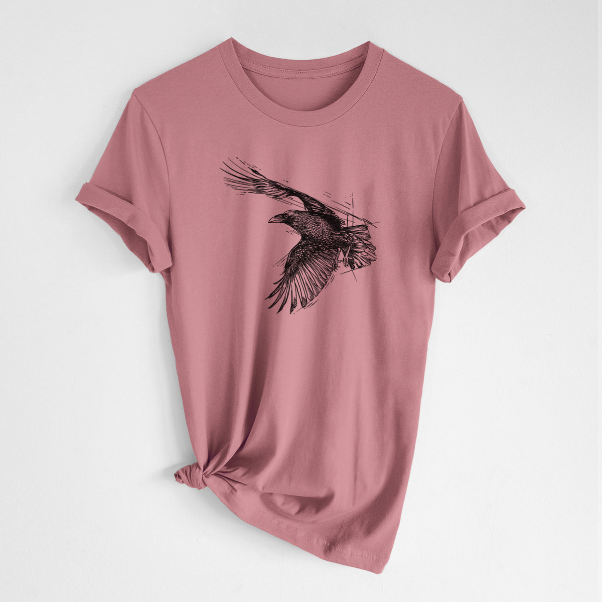 Mauve pink lightweight cotton t-shirt laid flat with the sleeves rolled, printed with a black ink illustration of a raven in flight with its wings spread.