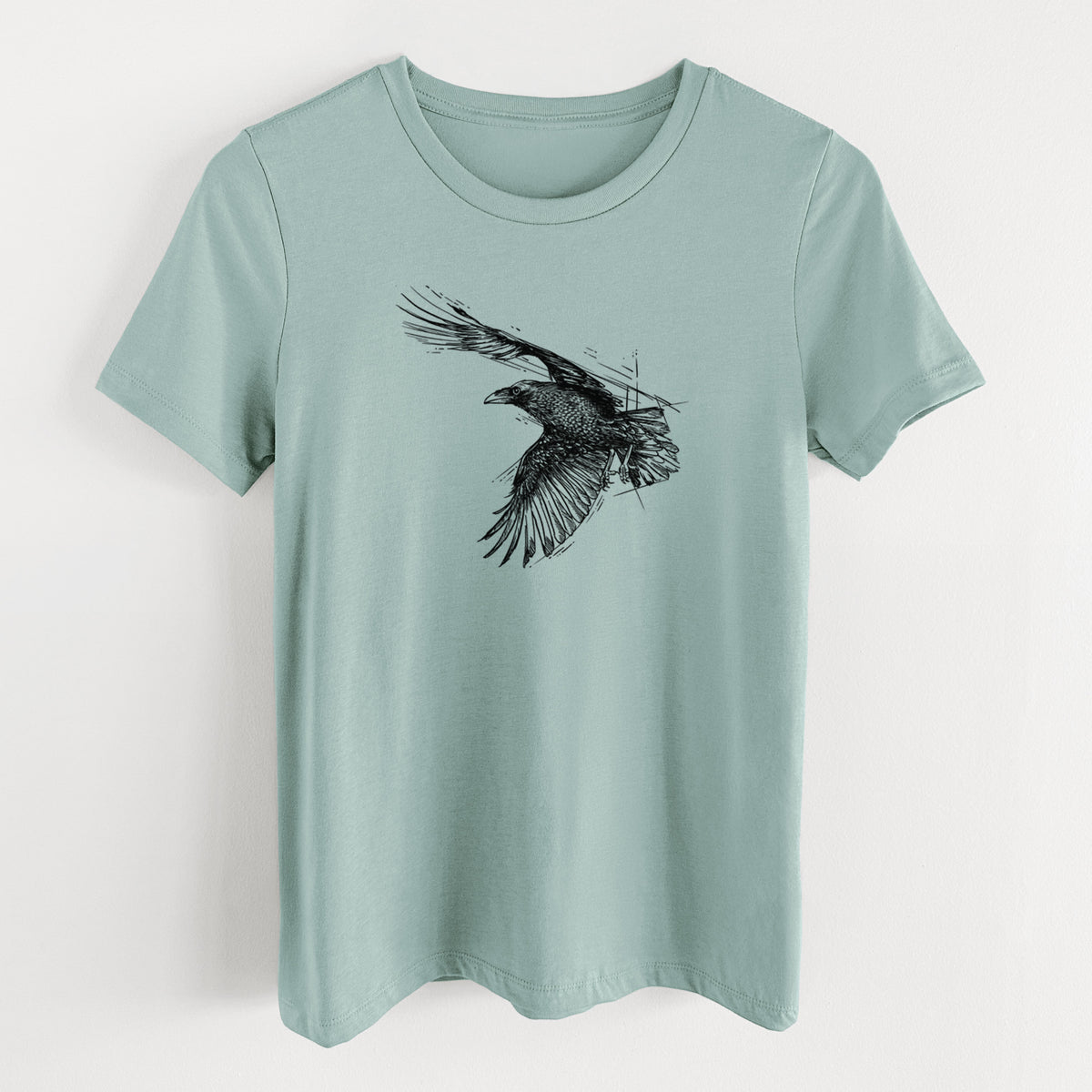Dusty blue women's relaxed fit cotton t-shirt laid flat, printed with a black ink illustration of a raven in flight with its wings spread.