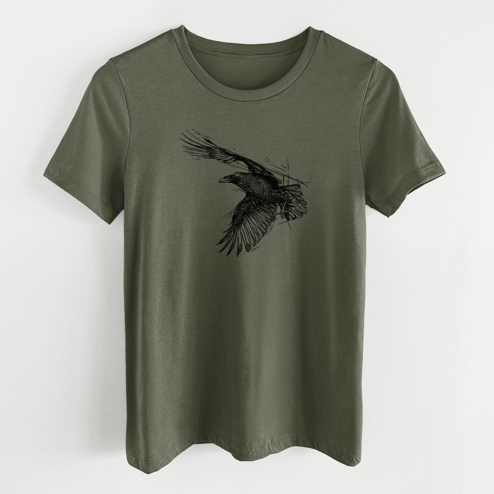 Military green women's relaxed fit cotton t-shirt laid flat, printed with a black ink illustration of a raven in flight with its wings spread.