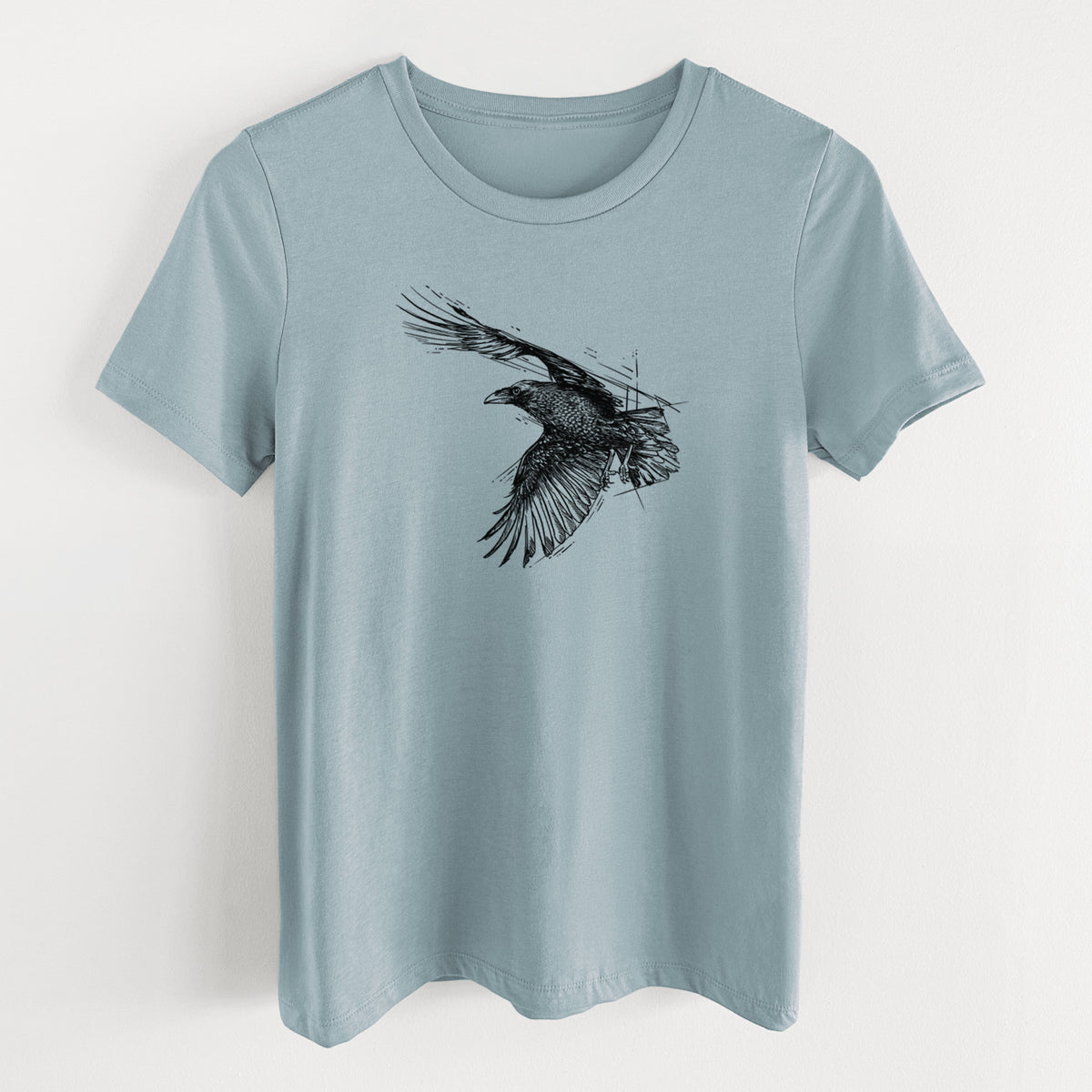 Vintage denim women's relaxed fit cotton t-shirt laid flat, printed with a black ink illustration of a raven in flight with its wings spread.