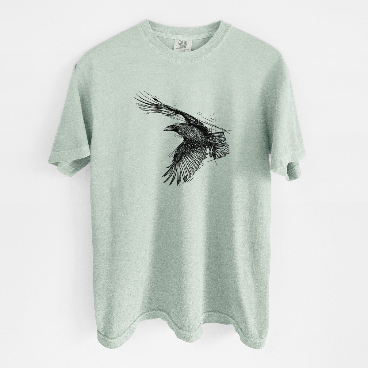 Bay green Comfort Colors t-shirt laid flat, printed with a black ink illustration of a raven in flight with its wings spread.