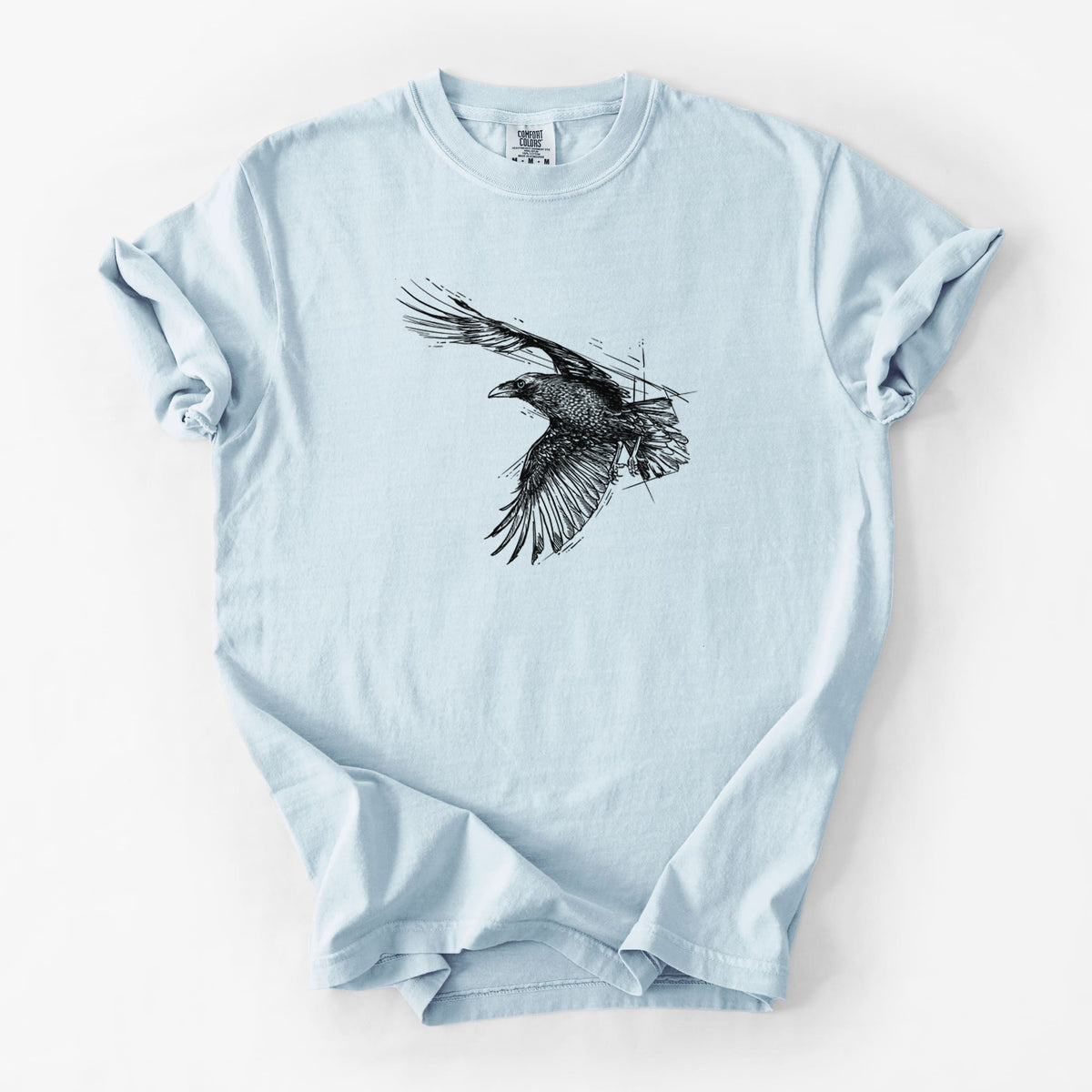 Chambray blue Comfort Colors t-shirt laid flat, printed with a black ink illustration of a raven in flight with its wings spread.